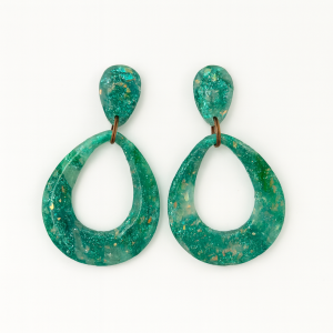 Handmade opal effect polymer clay teardrop earrings in baby teal with marbled green accents, finished with a resin gloss, displayed on a white background.