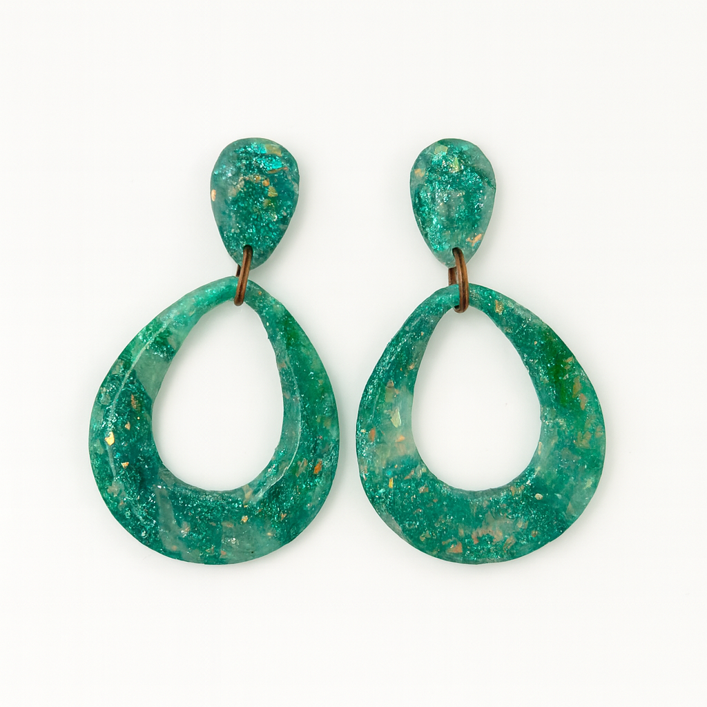 Handmade opal effect polymer clay teardrop earrings in baby teal with marbled green accents, finished with a resin gloss, displayed on a white background.